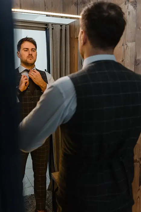 Man-Assessing-His-Personal-Brand-While-Getting-Dressed-At-The-Mirror