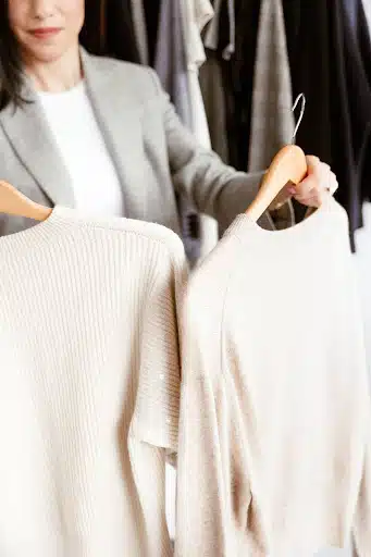 Cassandra holding up two sweaters