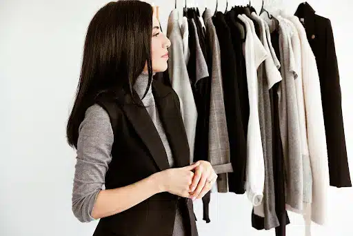 Cassandra in front of hanging clothes 