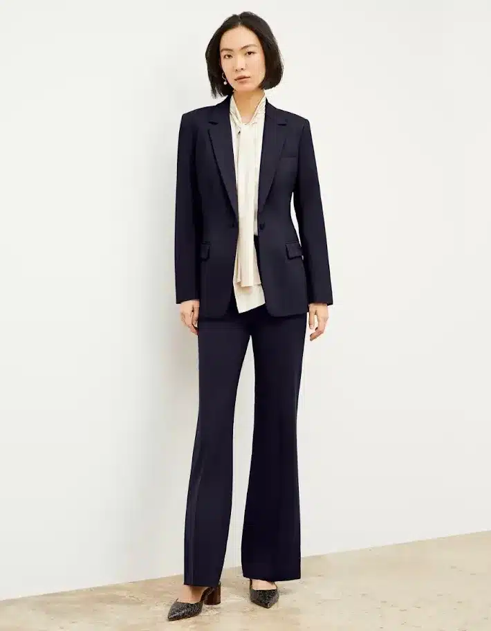 Executive woman wearing a tailored pantsuit with ivory blouse to depict modern attorney style
