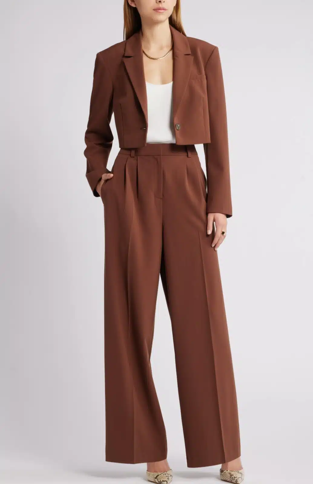 Image of a female lawyer in a power casual high-waisted trousers with pleated details, a lightly cropped blazer, and a fitted knit to.