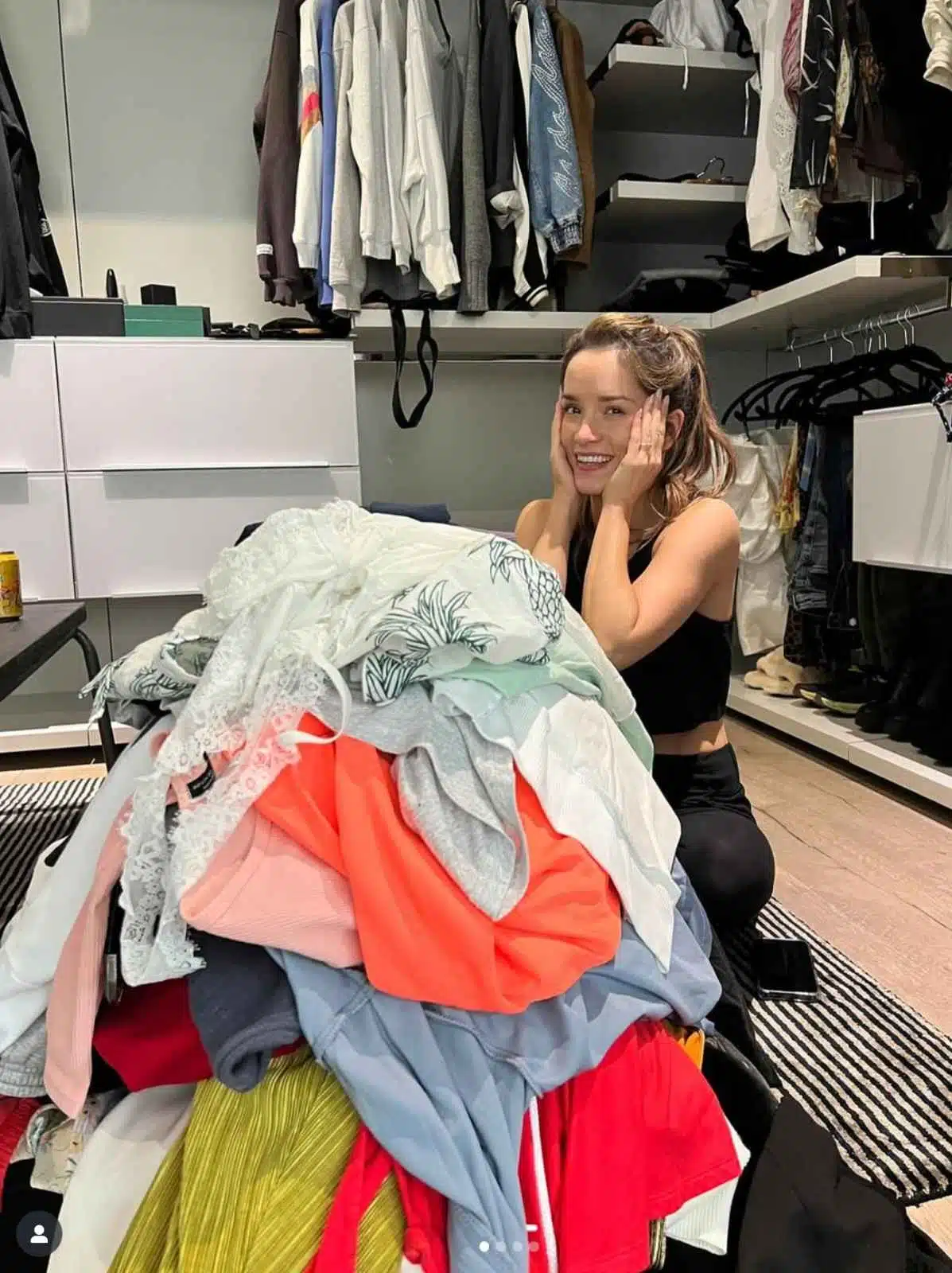 Image of Audrey Hussey, Matthew Hussey's wife standing over a pile of clothes that were removed during a closet cleanout.
